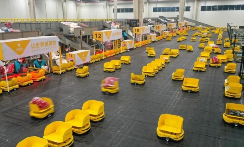 Workers assign parcels to robots at the logistics center of Fast Fish, a fast fashion retailer, in a smart logistics park in Deqing county, Huzhou city, east China's Zhejiang province, Jan. 4, 2022. [People's Daily Online/ Wang Shucheng]