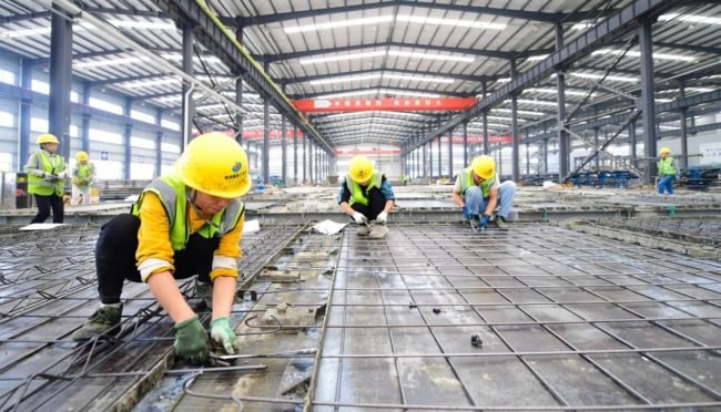Constructors are busy with work at a prefabricated building workshop in Ganzhou city, east China’s Jiangxi province, Nov. 3, 2021. (Photo by Hu Jiangtao/People’s Daily Online)